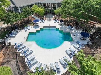 an aerial view of the resort style pool with chaise lounge chairs and umbrellas